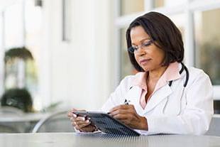 female doctor reading on tablet device